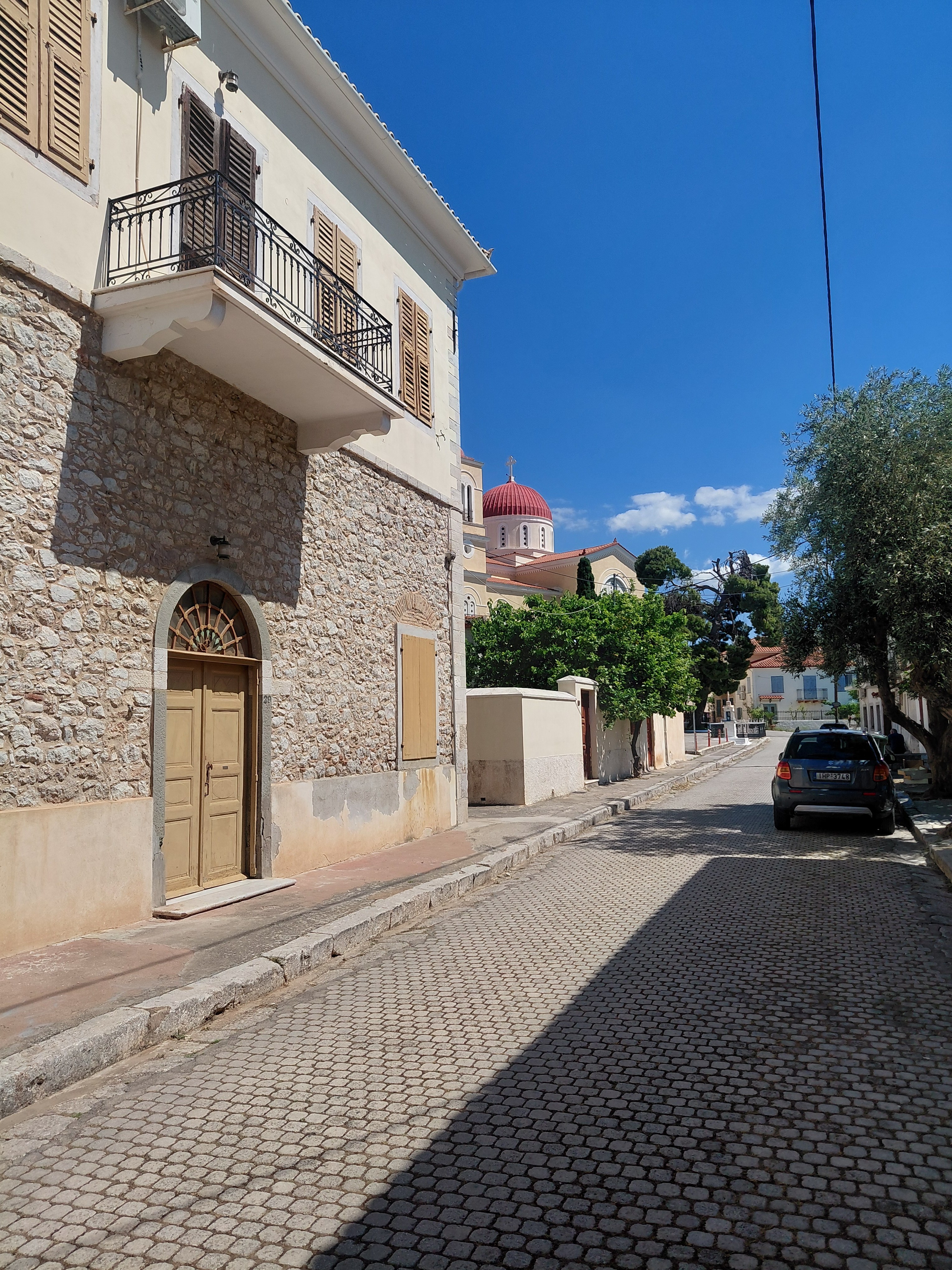 The mansion on its cobblestone lane, parish church behind